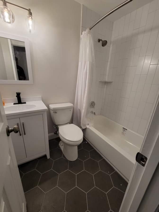 Shared bathroom with vanity and shower