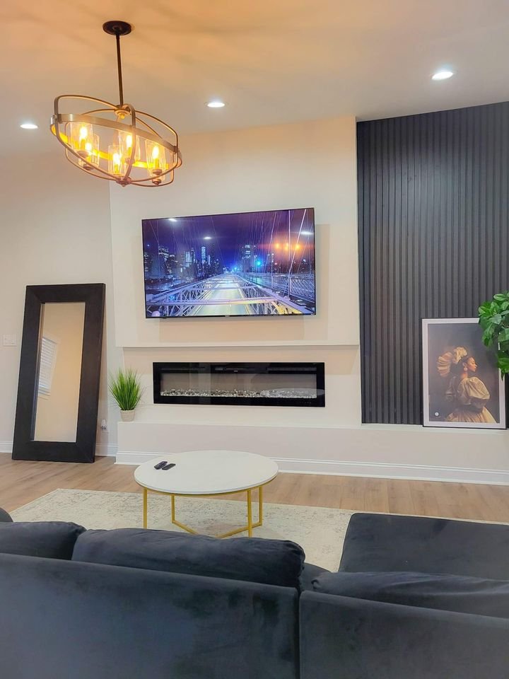 Living room with fireplace, accent wall, and chandelier